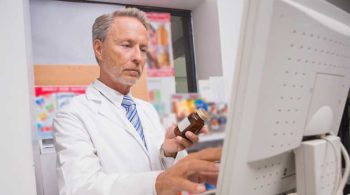 OARRS & Prescription Drug Abuse In Ohio Pharmacist looking at his computer OARRS system