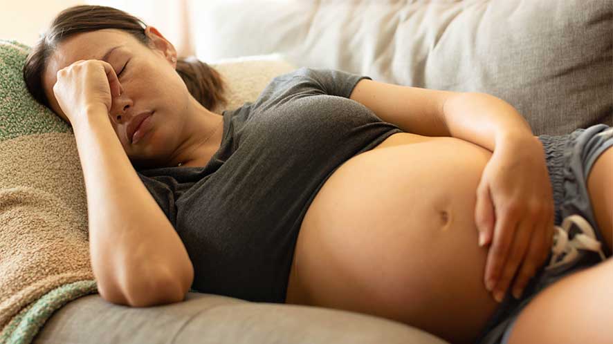 pregnant woman falling asleep on the couch - Can You Take Percocet While Pregnant?